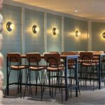 The Back Room function space at Settlers Inn Port Macquarie with high tables, bar stools and warm wall lighting.