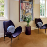 Seating area at Darlo Bar accommodation in Darlinghurst with armchairs, artwork and large windows.