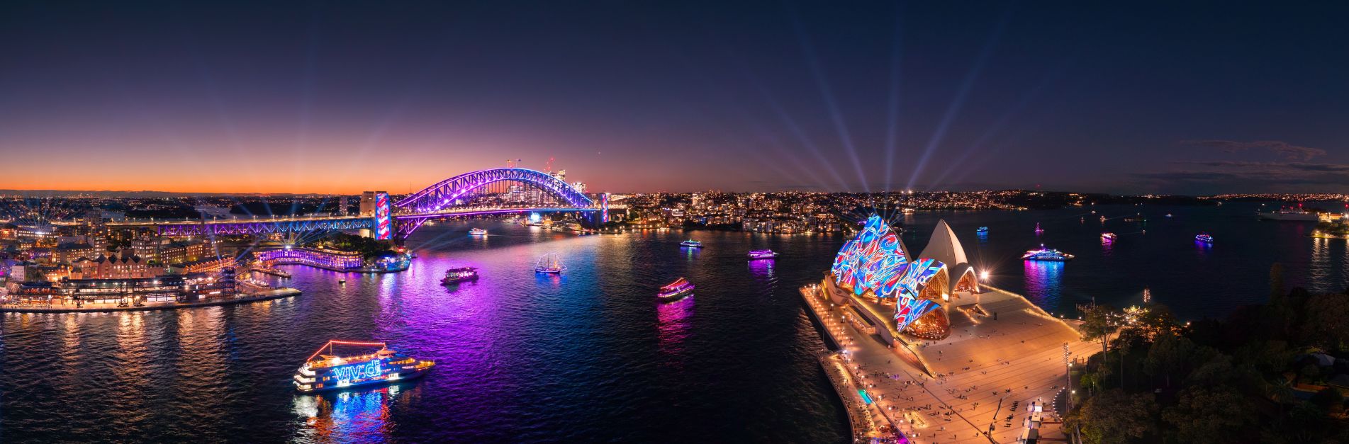 Vivid Sydney lights illuminating Sydney Harbour, Opera House and Harbour Bridge at night