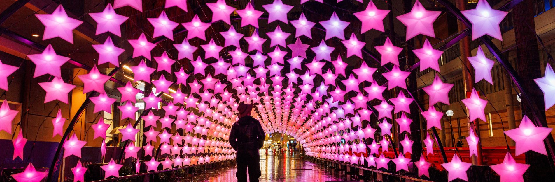 Vivid Sydney light installation tunnel with glowing pink stars in the city