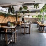 Terrace at Camden Hotel NSW featuring outdoor dining, hanging greenery, booth seating, and a relaxed atmosphere for drinks and casual dining.